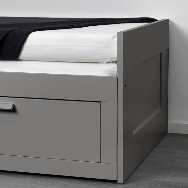 Grey day-bed with one drawer extended, neatly showing modern design and built-in storage.