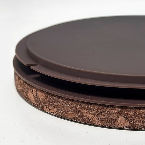 Close-up of smooth, dark, quality stoneware jar with a secure rubber gasket and cork lid.