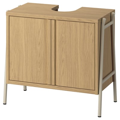 An oak BYASJÖN bathroom storage cabinet with two doors, a soft-close feature, and metal legs.