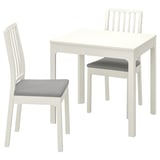 White wooden dining set with extendable table and two cushioned chairs.