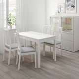 White dining set with extendable table and chairs, gray cushions, modern room.