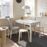 Minimalist dining set with extendable table and grey chairs in a bright kitchen.