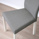 A modern dining chair with a sleek grey fabric and sturdy white legs.