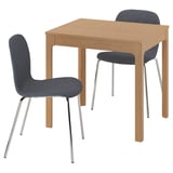 Small wooden dining set with two blue chairs and a rectangular table. Modern design with chrome legs and padded seats.