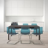 Modern dining set with extendable table and six teal chairs, perfect for accommodating large groups.