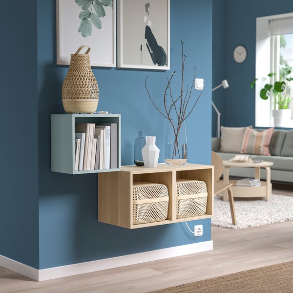 Modern living room with EKET shelves, books, vases, and a couch.