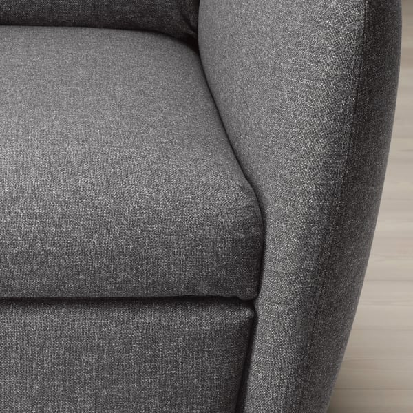 Close-up of a grey fabric recliner chair, showcasing its soft, rounded armrest and cushioned seat.