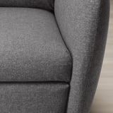 Close-up of a grey fabric recliner chair, showcasing its soft, rounded armrest and cushioned seat.
