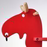 Bright red childrens toy with smooth finish; designed like a horse with wooden details and sturdy build.