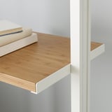 Wooden shelf attached to white bracket. Two white binders stacked on shelf.