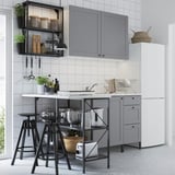 Modern kitchen with ENHET series: grey cabinets, black metal stools, white countertop, stainless steel appliances, hanging shelves, tiled backsplash.