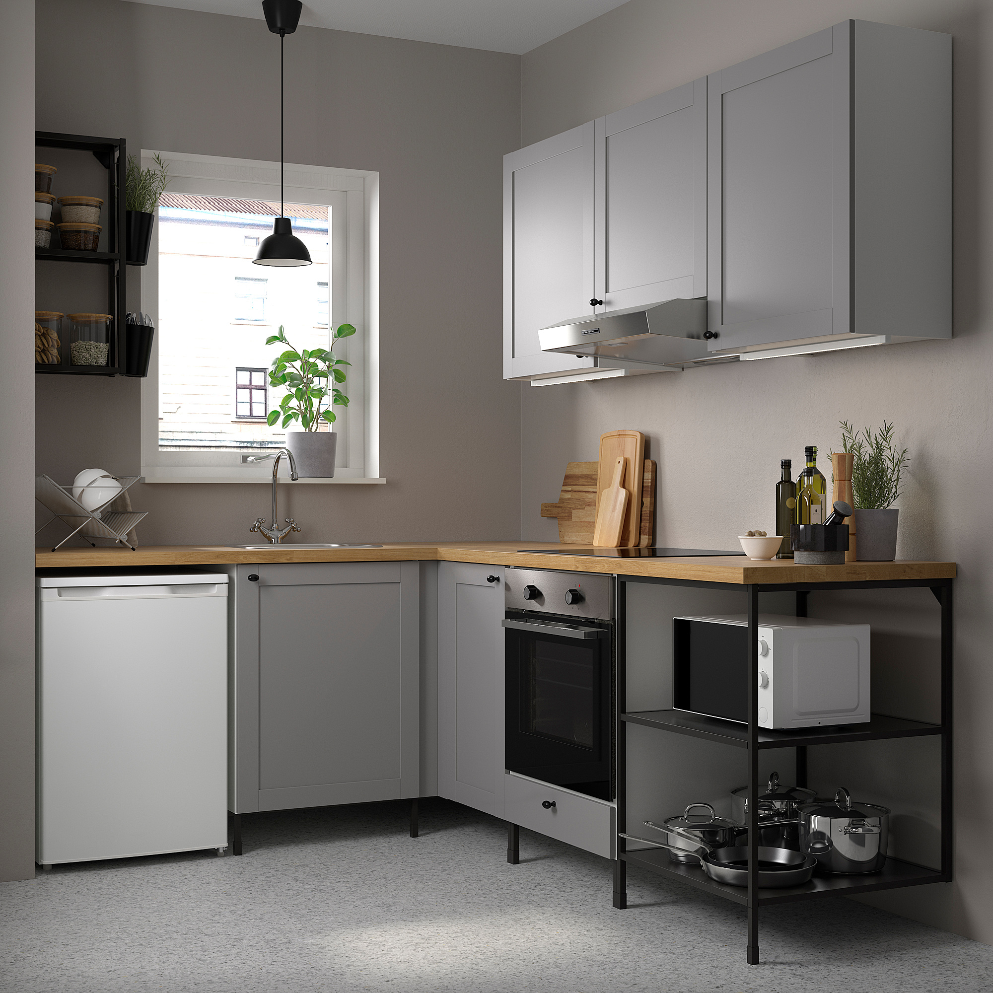 Small grey ENHET kitchen with wooden counter, white appliances, potted plants, and hanging light. Corner units maximize space.