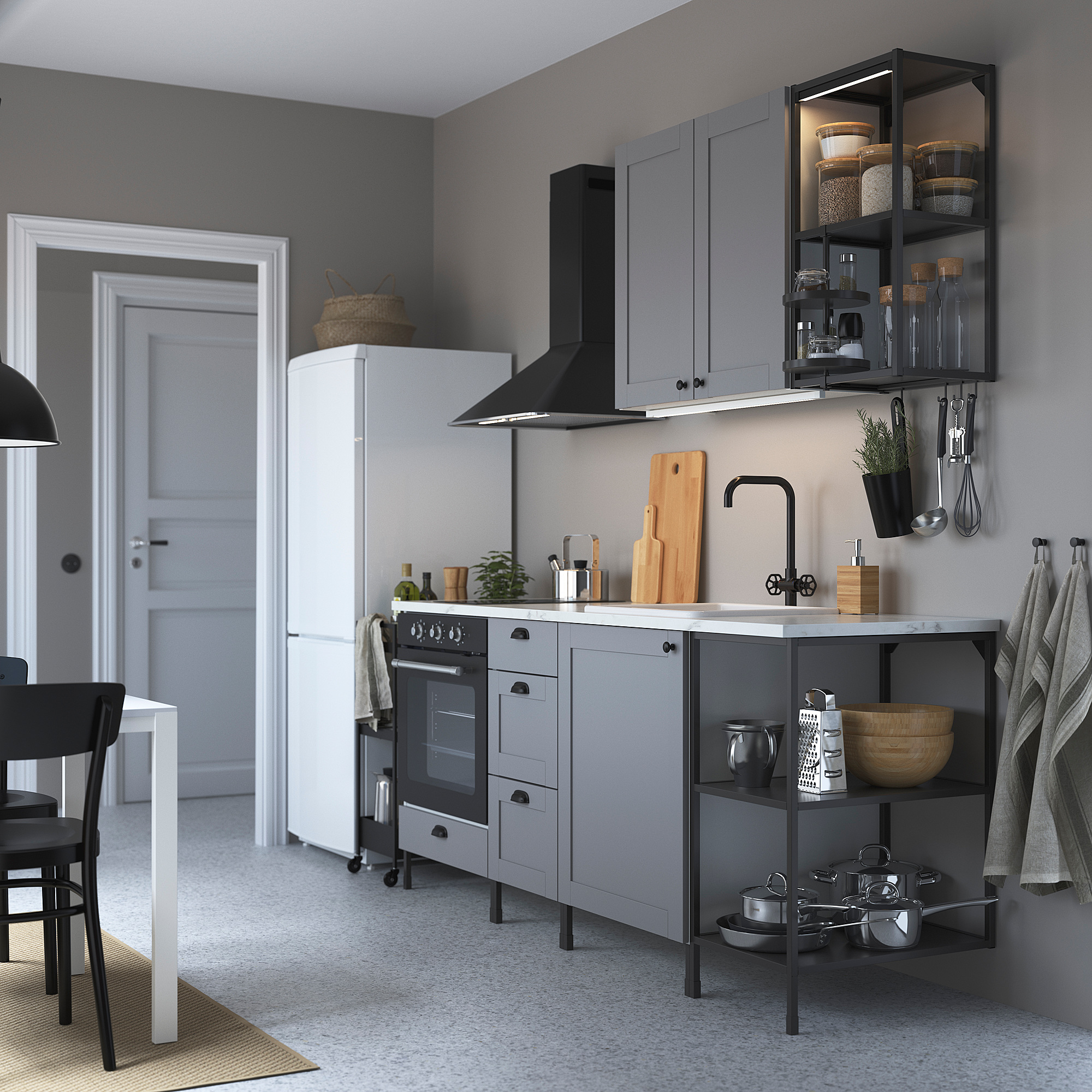 Modern grey kitchen with white fridge, black stove, marble countertop, wooden tools & hanging utensils. Compact yet well-organized.