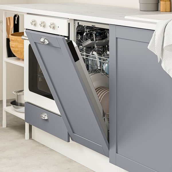 Open gray dishwasher in modern kitchen, showing clean dishes.