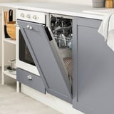 Open gray dishwasher in modern kitchen, showing clean dishes.