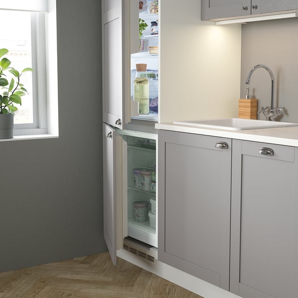 Modern kitchen with integrated fridge, sink, and stainless steel faucet. Soft-close cabinet and fully stocked fridge.