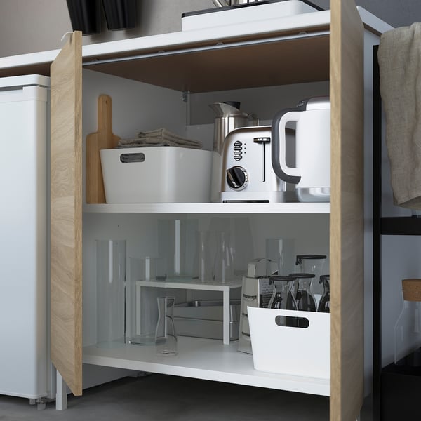 Kitchen cabinet with countertop appliances, organized storage containers, and glassware.