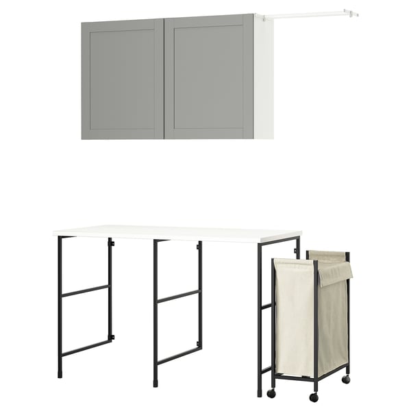 The ENHET laundry set, featuring a grey wall cabinet, a black metal foldable table, and a beige laundry bag on wheels.