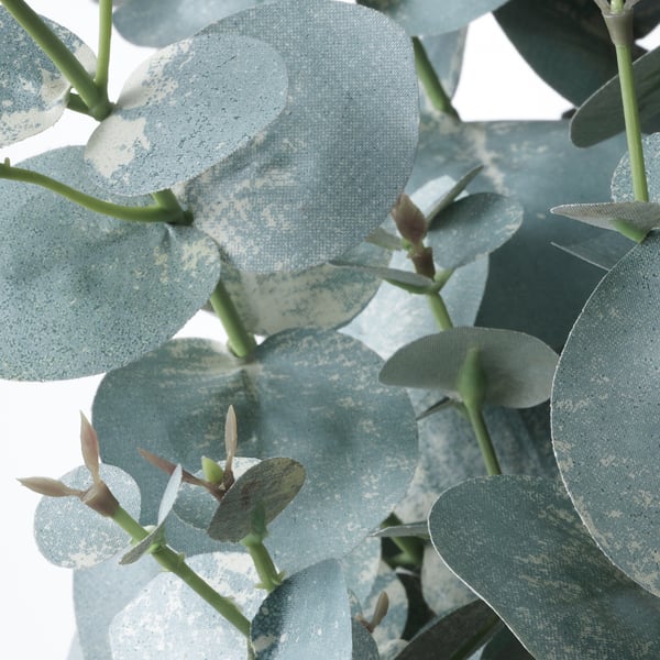 Artificial eucalyptus plant with realistic, dusty blue-green leaves on green stems.