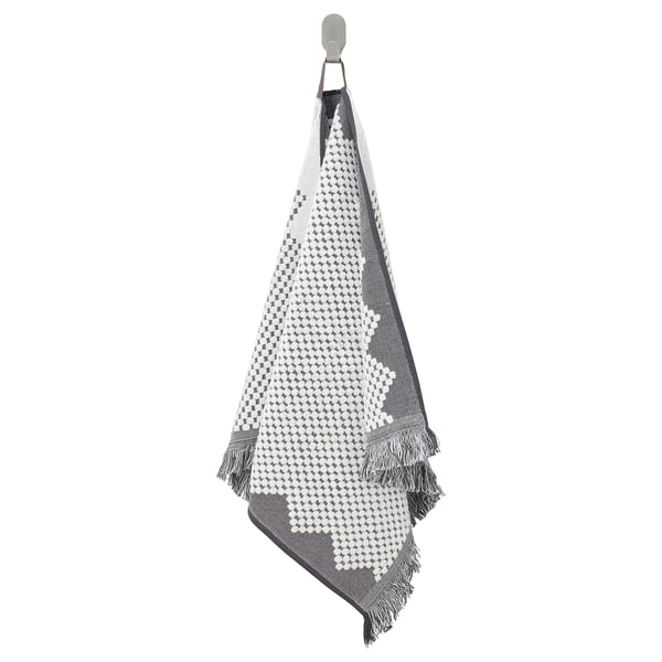 A FJÄLLSTARR towel in blue & white. The pattern is bohemian with fringe. Its woven from cotton and hangs on a hook.