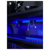 Gamer desk with blue led lights, usb cords, and robot toy. Black with sleek design.