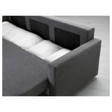 Modern grey sofa-bed with white cushions, featuring built-in storage for bedding and convertible seating.
