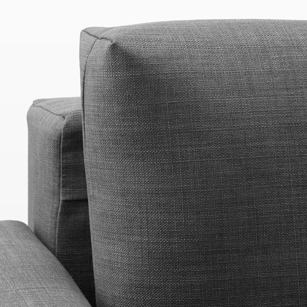 Close-up of modern, upholstered sofa corner, showing textured grey fabric and clean stitching.