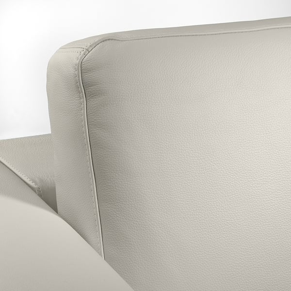 A plush, light grey leather sofa with sleek, modern lines, showcasing high-quality stitching and a smooth grain.