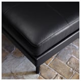 Black leather footstool with sleek design and metal legs. Perfect for relaxing.