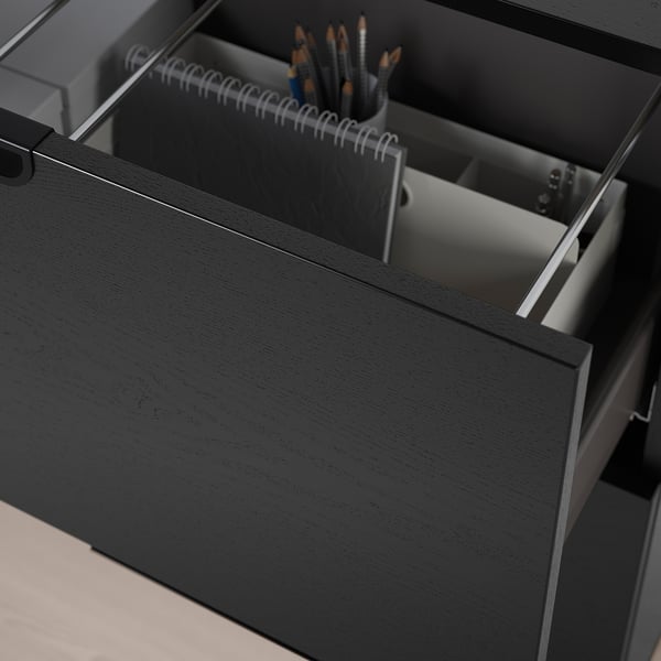 Black office drawer open, revealing organized office supplies, showcasing secure storage with a lock mechanism.