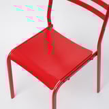Bright red metal chair, sleek and modern design, sturdy frame.