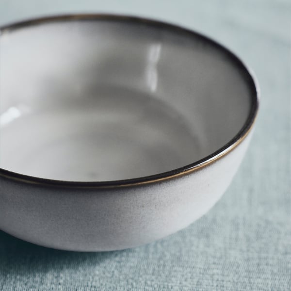 Elegant bowl with smooth glaze on blue background.