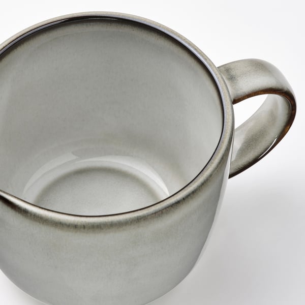 Sleek, stoneware jug with speckled gray glaze, sturdy handle for comfortable grip.
