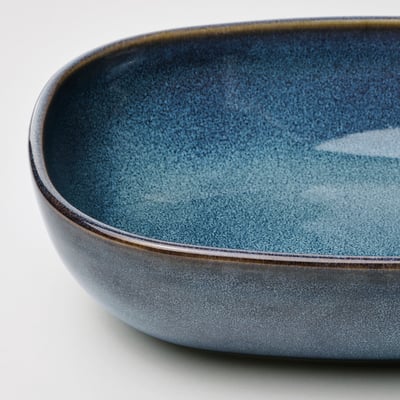 Two blue stoneware oven dishes, oval shaped with golden rim, sit side by side.