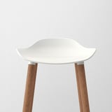 Modern bar stool with sleek white seat, sturdy wooden legs, minimalist design.