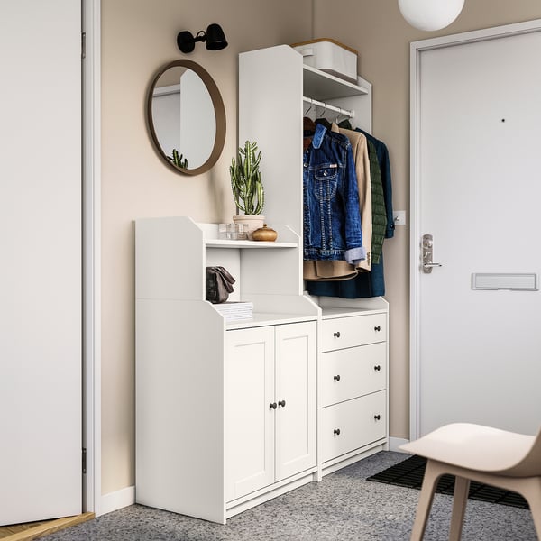 Modern entryway setup with white HAUGA storage, cactus, and hanging jackets.