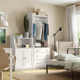 Modern bedroom with HAUGA white cabinet, cactus, and chair.