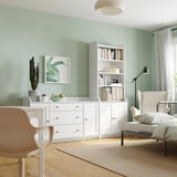 Modern living room with green walls, white furniture, recliner, and floor lamp.