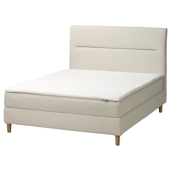Minimalist ivory bed with padded headboard, wood legs, and white mattress.
