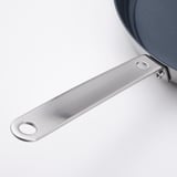 A sleek handle on a high-quality stainless steel pan; part of durable, non-stick cookware set.
