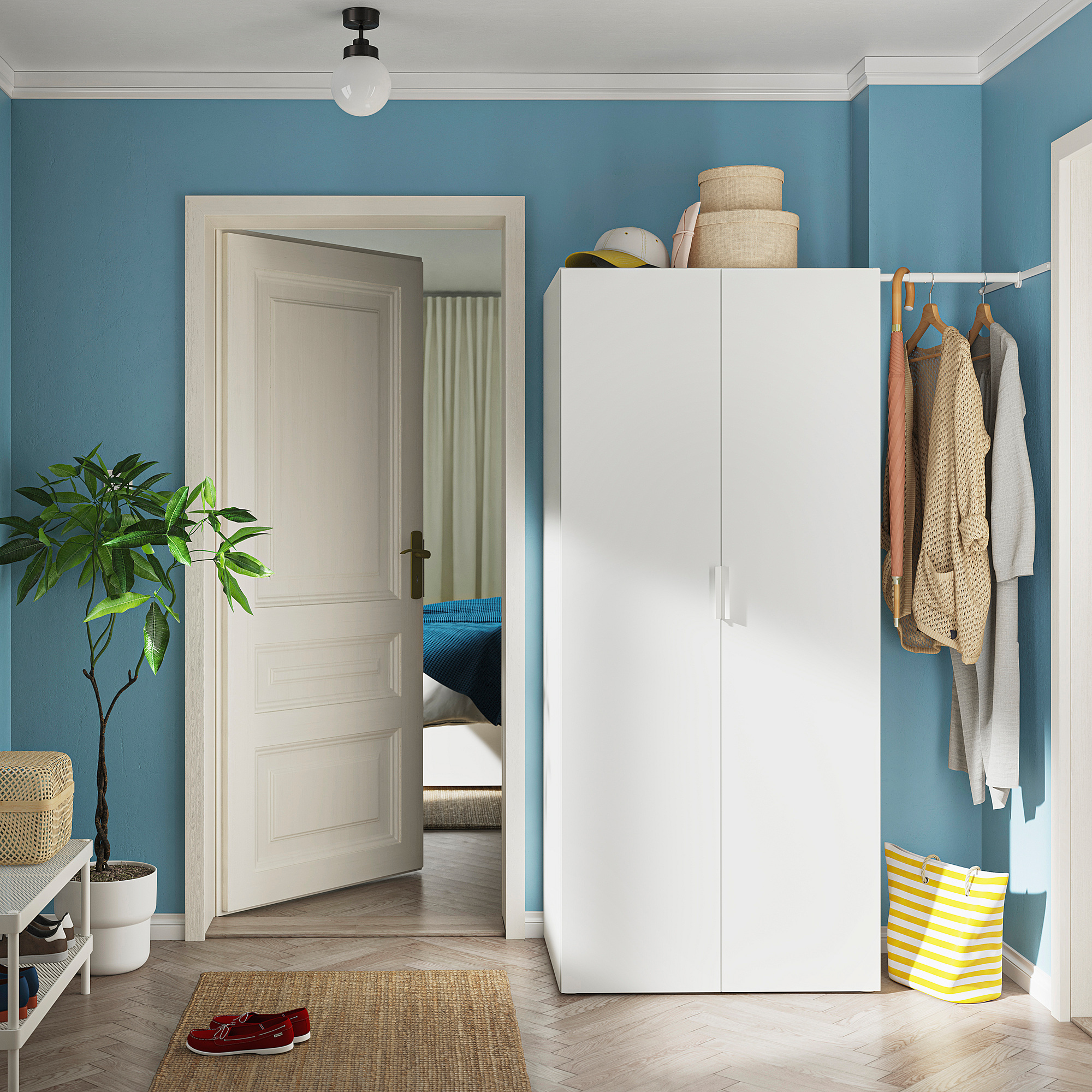 A tidy blue room with a white HJÄLPA storage unit. The unit has baskets, clothes on hangers, and a plant beside it.