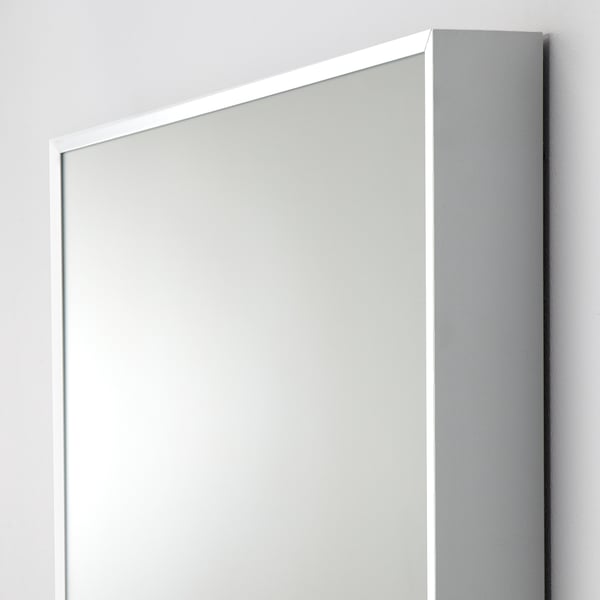 Large, sleek mirror with narrow frame, leaning against wall. Modern, minimalist design. Safety film on glass.