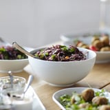 Bowls of salad on wooden table; IKEA containers stacked neatly.