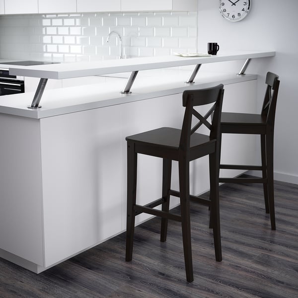 Two black INGOLF bar stools near a kitchen island with a mug on it.