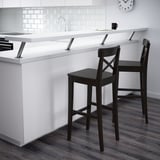Two black INGOLF bar stools near a kitchen island with a mug on it.