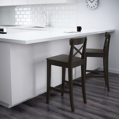 Dark wood bar stools with backs at white kitchen island.
