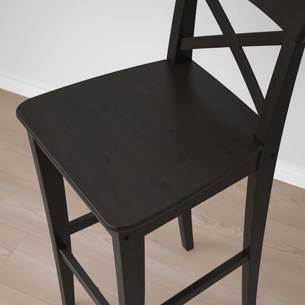 Black wooden bar stool with square seat and backrest, part of the INGOLF series, placed on a light wooden floor.