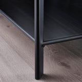 Black metal-framed furniture piece with a sleek, matte finish placed on a wooden floor. Clean lines and sturdy construction suggest high quality.