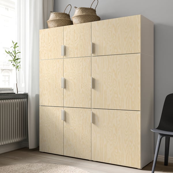 Light wooden cabinet with four doors, placed against a wall. The cabinet has silver handles and two woven baskets on top.