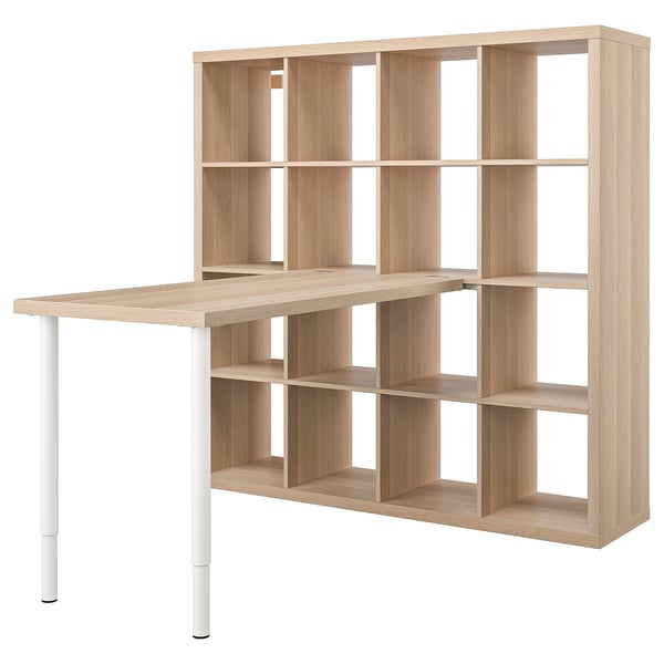 A light wood KALLAX shelving unit with a built-in desk, featuring multiple open cubes for storage.